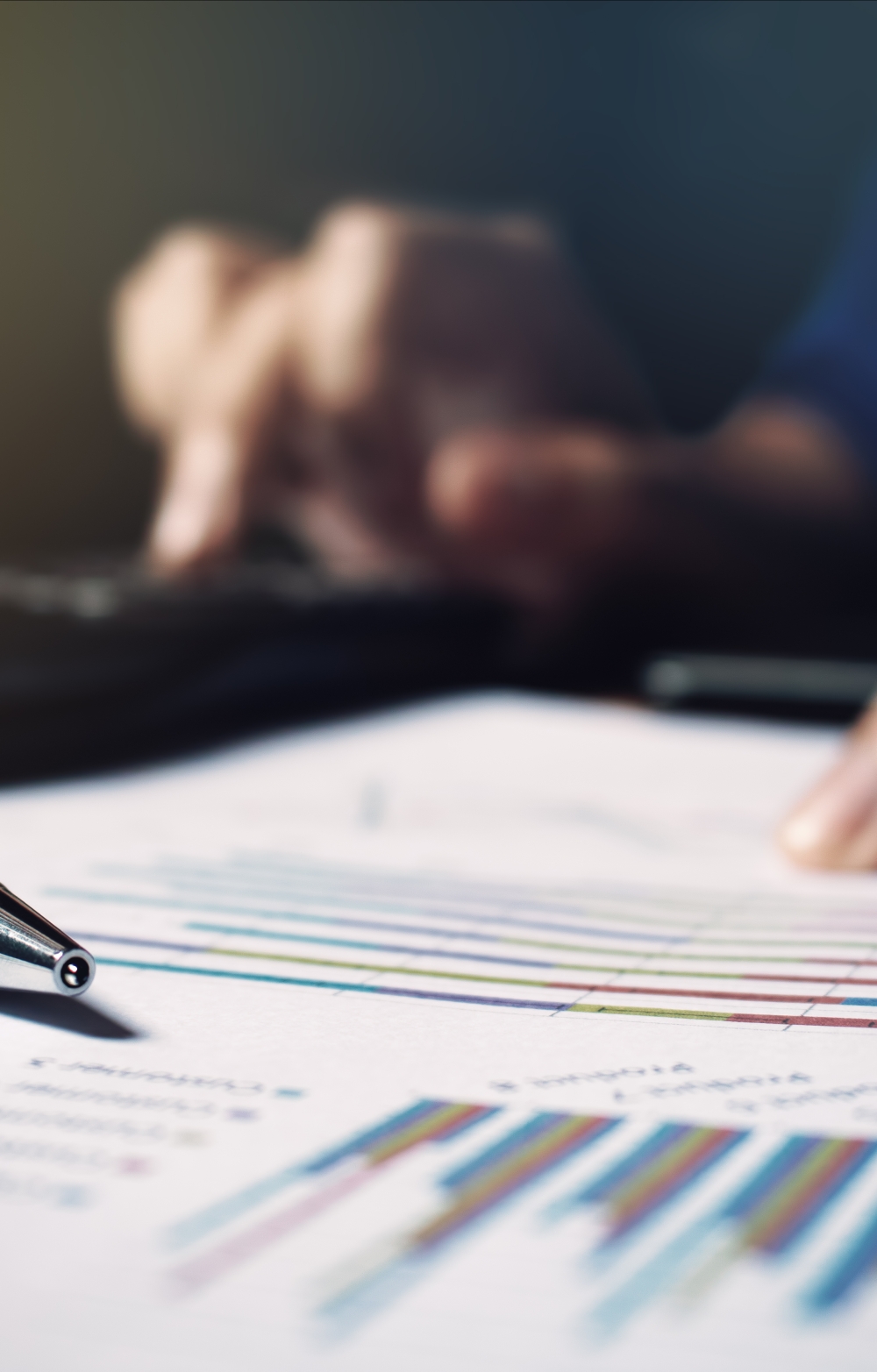 fingers tracing figures on a chart on paper with a pen nearby