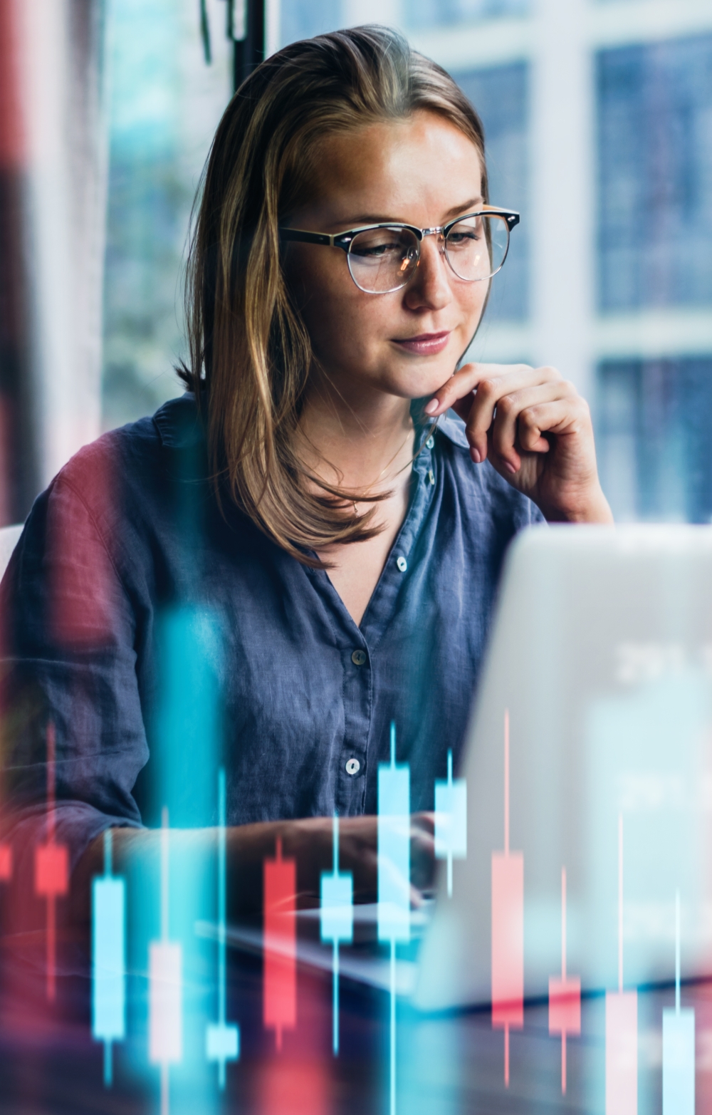 Pensive lady looking at her laptop screen against an imaginary background of statistical bar charts