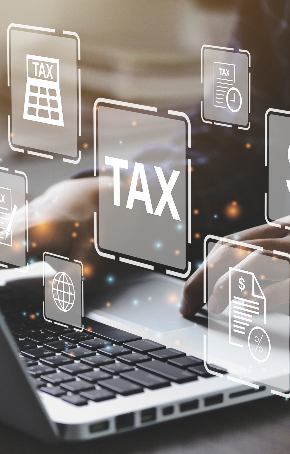 hands typing on a laptop on a backdrop of the words Tax and Dollar sign