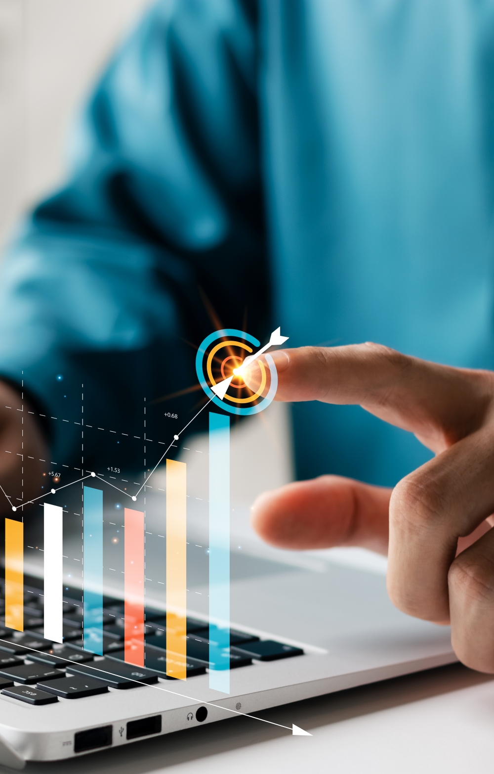 finger of a hand of a man in a blue shirt pointing at a virtual bar chart emanating from the keyboard of a laptop
