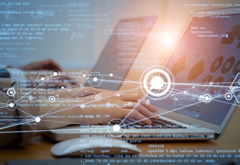 Hands on brightly coloured laptop keyboards with screens displaying statistical charts