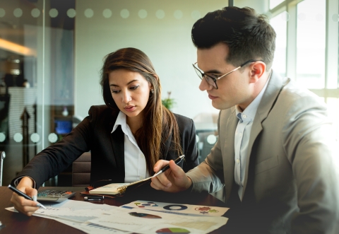 2 people examining a document carefully
